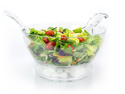 Chilled salad bowl on ice with spoon and fork